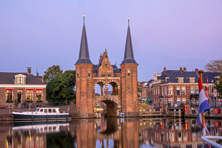 The watergate in the historical city Sneek in Friesland the Netherlands at sunset with the dutch flagの写真素材