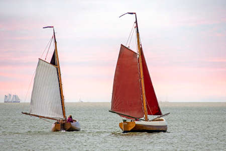 Traditional dutch wooden boats at the IJsselmeer in Friesland the Netherlands at sunsetの写真素材