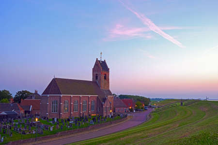 The traditional village Wierum at the Wadden Sea at sunset in Friesland the Netherlandsの写真素材