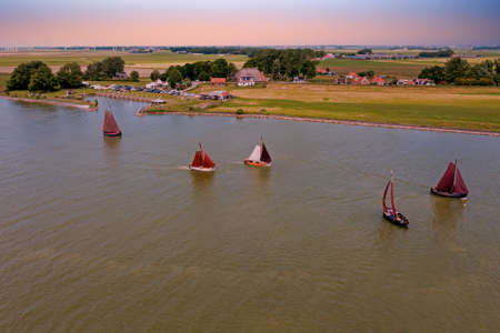 Aerial from traditional dutch wooden boats at the IJsselmeer near the harbor from Laaxum in Friesland the Netherlands at sunsetの写真素材
