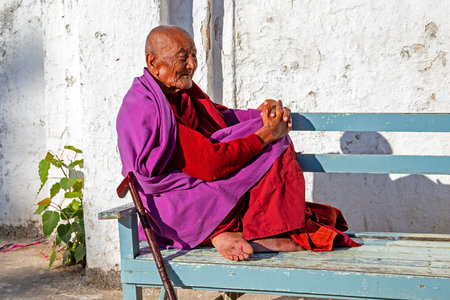 Bagan, Myanmar - November 24, 2015: Old monk contemplating on a bench in Bagan, Myanmar