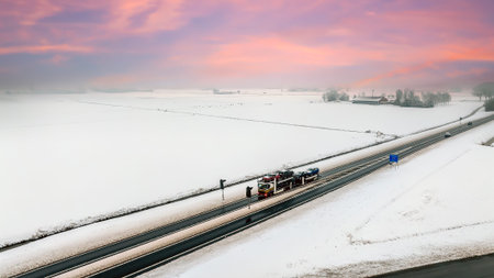 Car transporter truck driving through a winter landscape