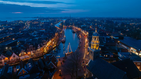Night View of City with Illuminated Church Tower and Boats in the harbor