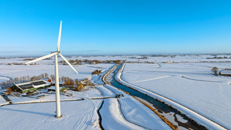 Aerial View of a Wind Turbine in Snowy Countryside During Winter