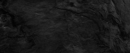 Panorama dark gray stone background with copy space. Black grunge banner with rock texture.The...