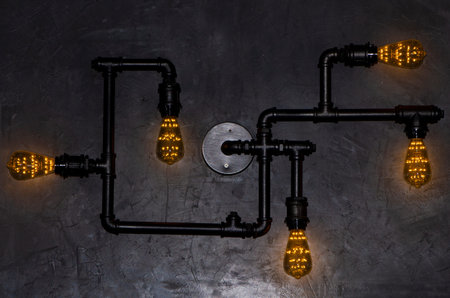 Antique Edison style decorative lamp against cement wall background and wallpaper decorative design.