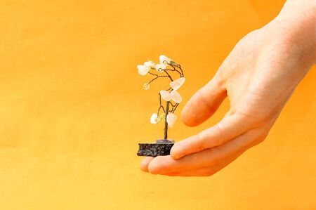 Hand with artificial metal tree. A symbol of happiness and fortuneの写真素材