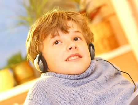 Boy listen to music in warm sunny bedroomの写真素材