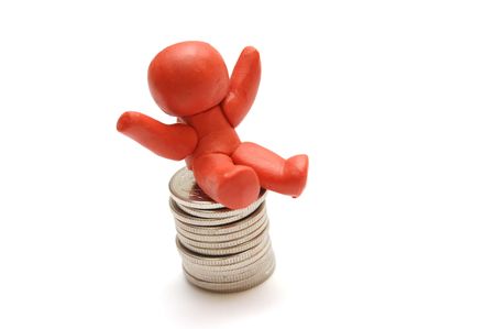 Plasticine figure sitting on coins pile. Winner in businessの写真素材