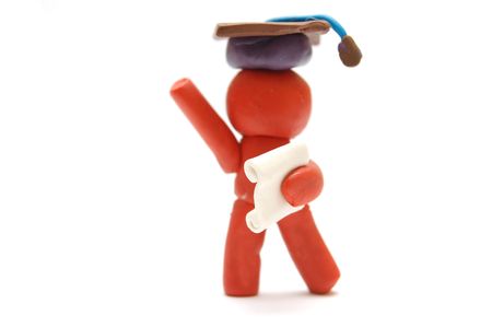 Plasticine figure celebrating graduation with certificate and student hatの写真素材