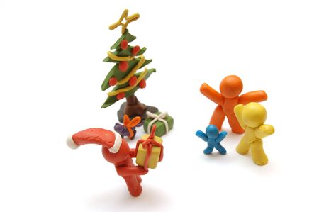 Plasticine figures staying together and celebrating christmas time, Santa Clous giving away presentsの写真素材