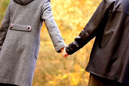 Hand-in-hand. Couple love in autumn sceneryの写真素材