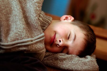Sleepy boy. Tired falls asleep on stairsの写真素材