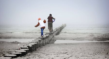 Parenthood. Mother playing with her childer on the beachの写真素材