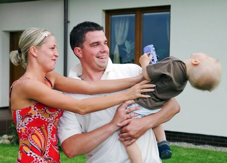 Happy family in front of their houseの写真素材