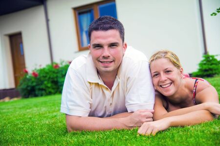 Happy couple in front of their ideal houseの写真素材