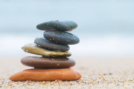 Stack of beach stones on sand. Ocean in the backgroundの写真素材