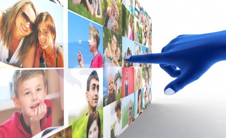 Social media network. Blue hand pointing at screen full of people, facesの写真素材