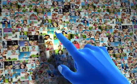 Social media network. Blue hand pointing at screen full of people, facesの写真素材