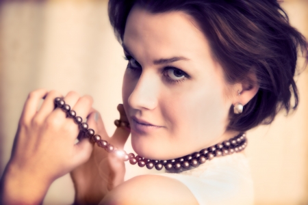 Young elegant lady with gold necklace in glamour, beauty fashion. Smiling confidentの写真素材