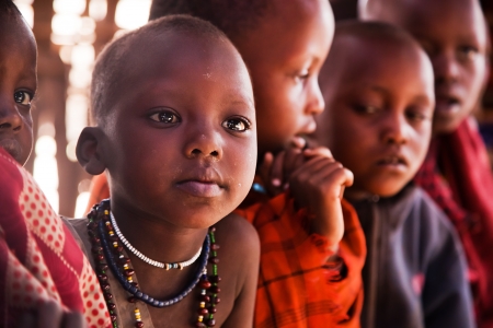 Maasai village, TANZANIA, AFRICA - DECEMBER 11: Maasai children portrait in their local school on December 11, 2012 in Ngorongoro Tanzania. Maasai children learn basic sciences and the English language in schools located next to their villagesのeditorial素材