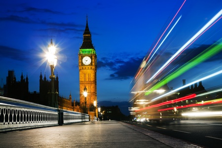 London, the UK. Red bus in motion and Big Ben, the Palace of Westminster at night. The icons of...