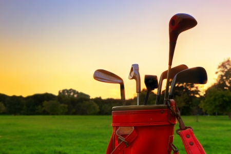 Golf equipment. Professional golf clubs in a leather baggage at sunsetの写真素材