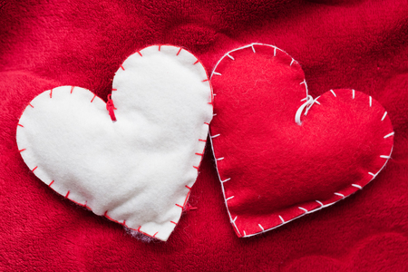 Handmade plush red hearts couple on soft blanket. Romantic love, Valentine's Day concepts.の写真素材
