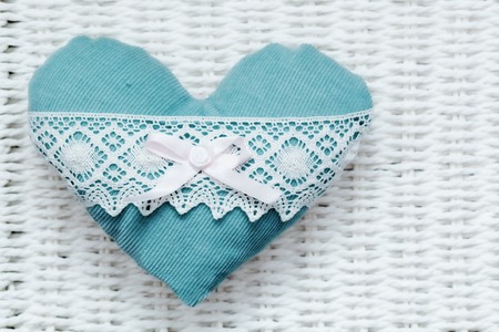 Vintage handmade plush turquoise heart on white rustic wicker. Romantic love, Valentine's Day concepts.の写真素材