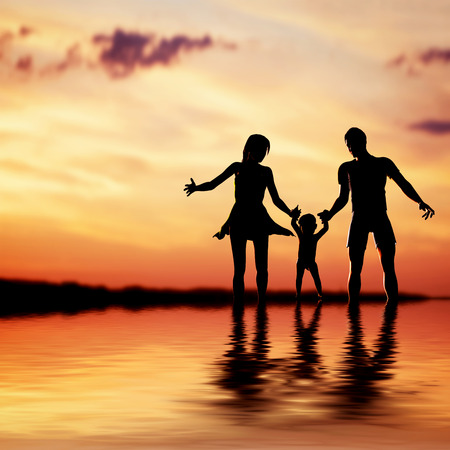 Happy family walking together hand in hand at sunset  Mother, father and a little childの写真素材