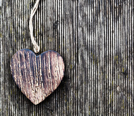 A wooden vintage heart on grunge wood planks. Symbol of love, Valentine's Dayの写真素材