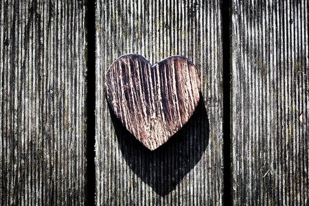 A wooden vintage heart on grunge wood planks. Symbol of love, Valentine's Dayの写真素材