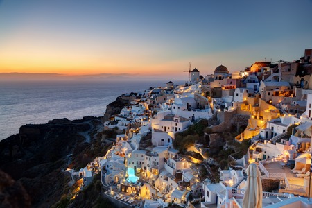 Oia town on Santorini island, Greece at sunset. Traditional and famous windmills on cliff over the Caldera, Aegean sea.の写真素材