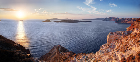 Cliff and volcanic rocks of Santorini island, Greece. View on Caldera and Aegean sea at sunsetの写真素材