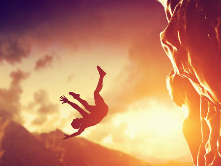 Hiker free falling from the mountain, cliff. Concept of man in dangerous or fatal situation, accident.の写真素材