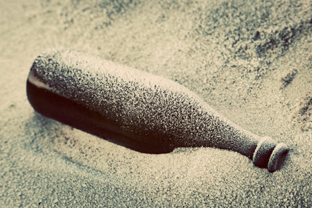 Old frozen bottle lost on the beach. Winter cold.