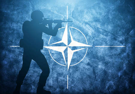 Soldier silhouette on grunge NATO flag. United army, military concept.のeditorial素材