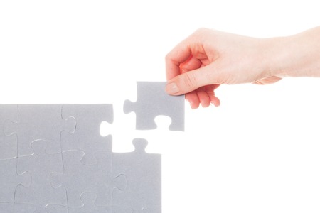 Completing the last piece of jigsaw puzzle. Isoalted on white. Search for the solution, solving the problem, answer, business connection concept.の写真素材