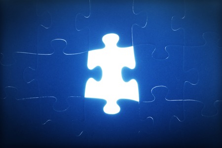 Jigsaw puzzle piece missing. Light glow from empty space. Search for the solution, solve the problem, answer, business connection concept.の写真素材