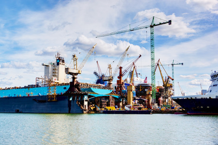 Shipyard. Ship under construction, repair. Industrial machinery, crane. Transport.の写真素材