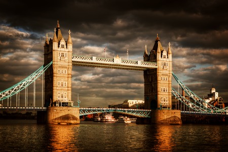 Tower Bridge in London, the UK. Dramatic stormy and rainy clouds with sunset sun shining. One of the symbol of England, Great Britainのeditorial素材
