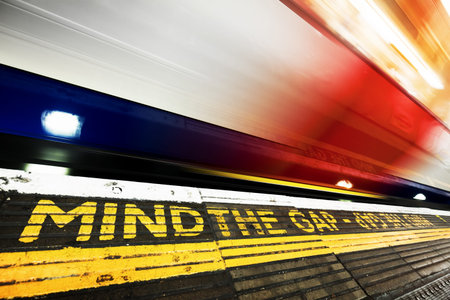 London underground, tube. Mind the gap sign painted on the floor. Train speeding in motion....