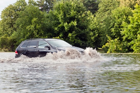 GDANSK, POLAND - July 28: Car trying to drive against flood on the street on July 28, 2015 in Gdansk, Poland. Storms and heavy rains hit many parts of Poland and Europeのeditorial素材