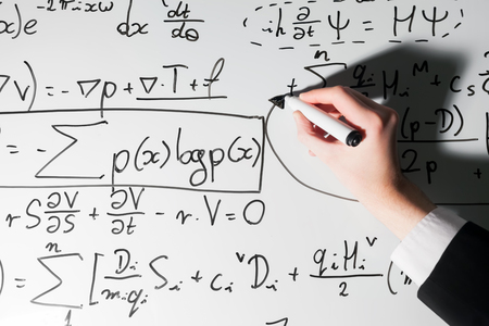 Man writing complex math formulas on whiteboard. Mathematics and science with economics concept. Real equations, symbolsの写真素材