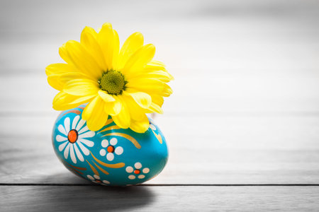 Hand painted Easter egg and spring daisy flower on wood. Rustic minimalist composition, vintage
