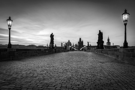 Charles Bridge at sunrise, Prague, Czech Republic. Dramatic statues and medieval towers. Unique view at dawn when there are almost no people on the bridge. Black and whiteの写真素材