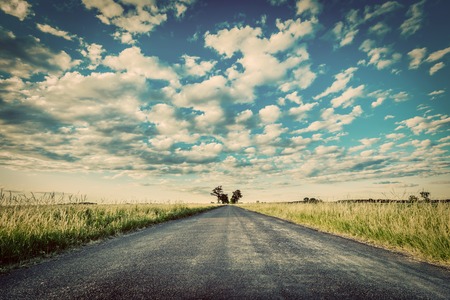 Empty straight long asphalt road. Dramatic cloudy sky. Concepts of travel, adventure, destination, transport etc. Vintage styleの写真素材