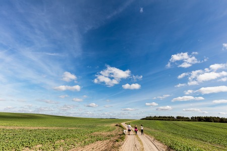 Family walk in countryside. Summer field, sunny day.の写真素材