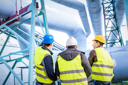 Engineers discussing maintenance of a petrochemical plant. Technical inspection. Oil and gas...