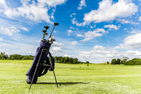 Golf equipment bag standing on a course. Summer sport and activity.の写真素材